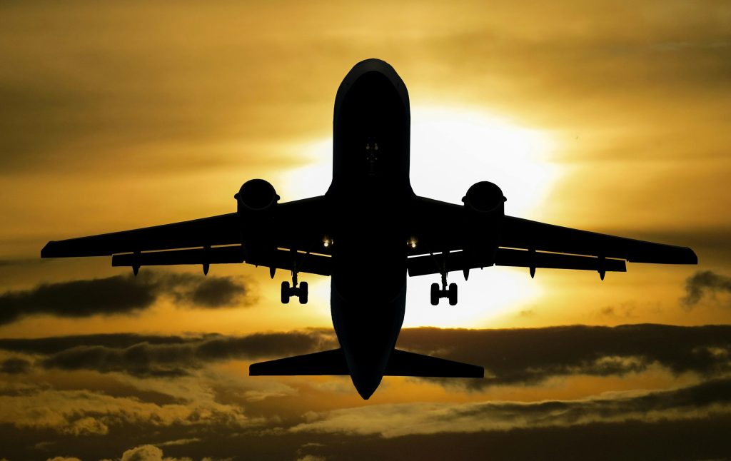 aircraft-holiday-sun-tourism-99567-99567 Silhouette of an airplane flying against a dramatic sunset sky.